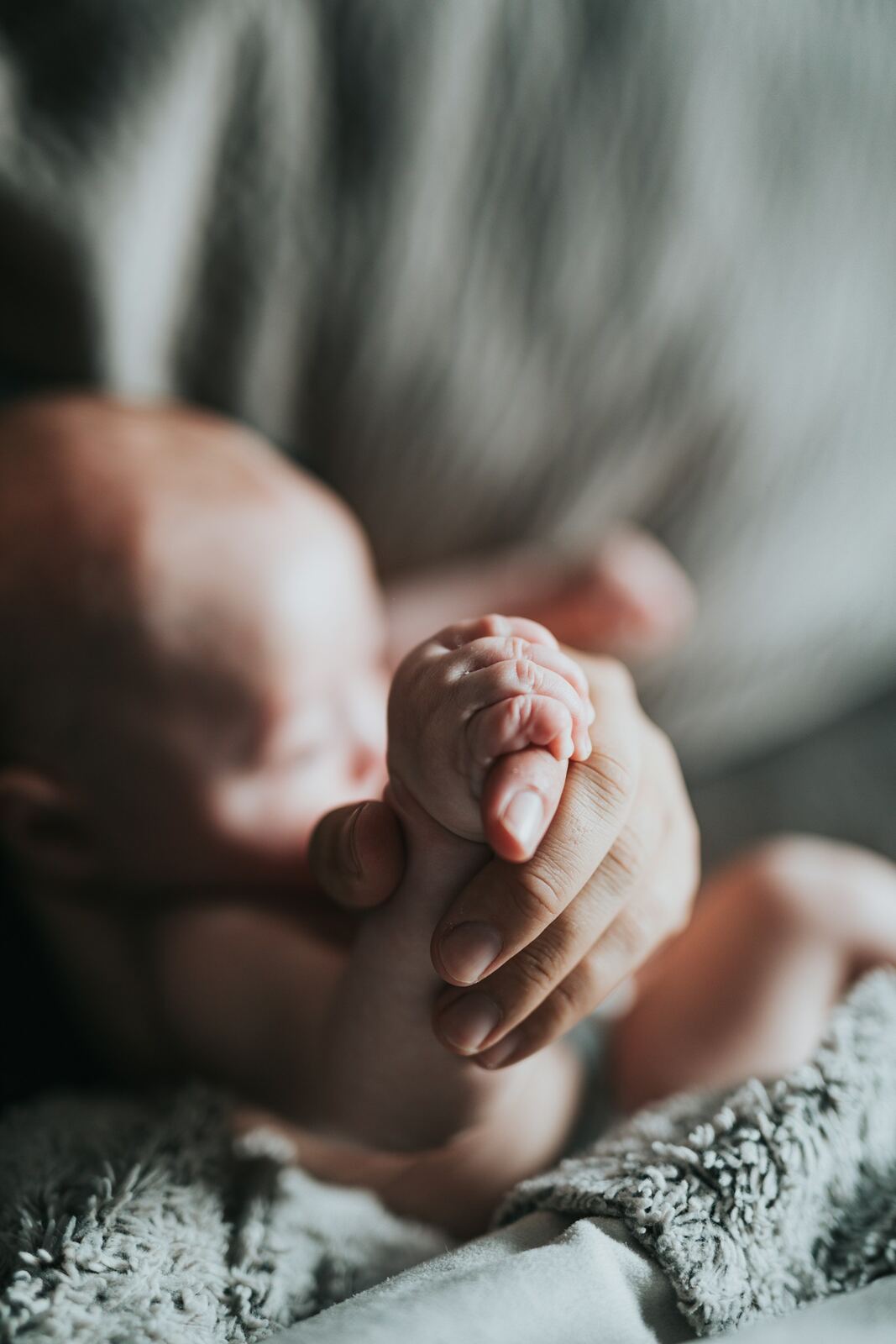 Detalhe da mãozinha do bebê, em luz suave